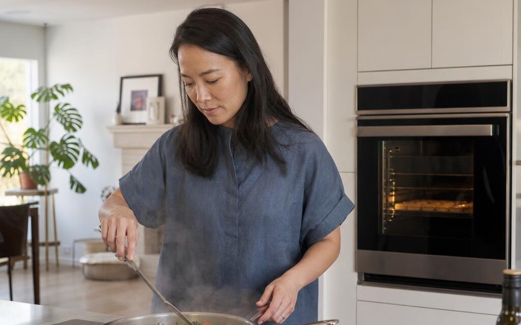 Homeowner cooking on an induction cooktop with a convection oven nearby